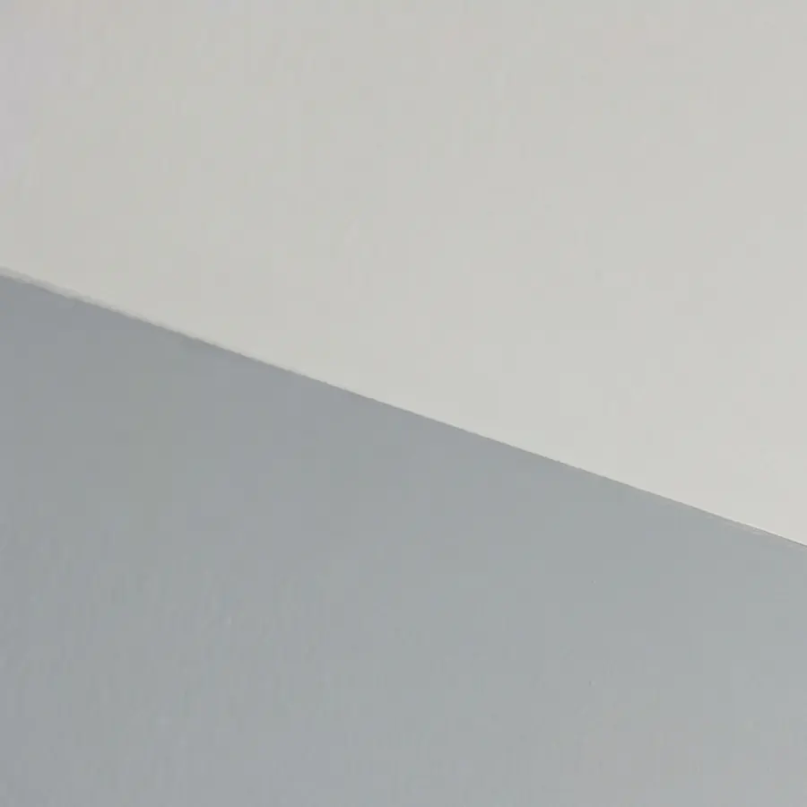 Straight cut-in line where a pale blue-grey wall meets a white ceiling